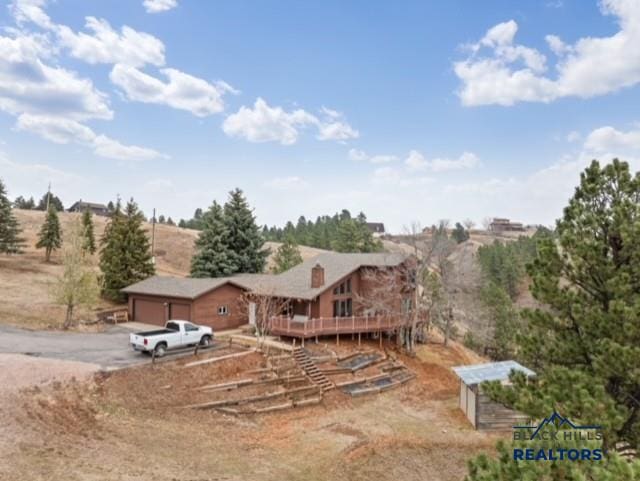 view of front of home with a wooden deck and a rural view