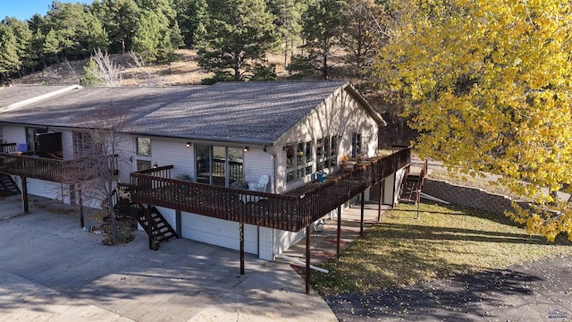 view of front of house featuring a garage, a front yard, and a wooden deck