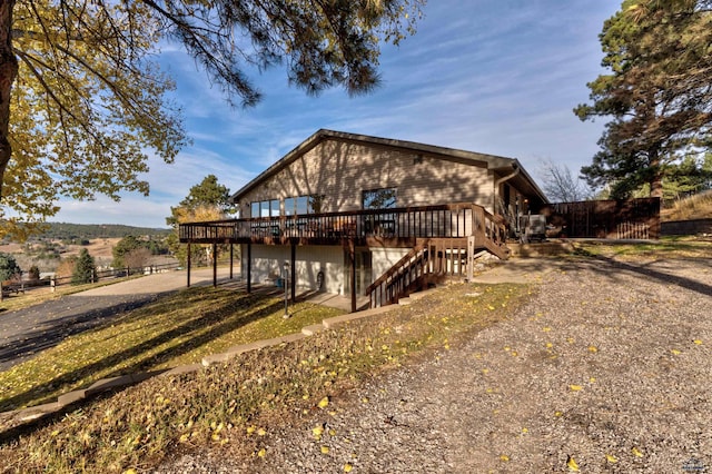 view of front of home with a rural view and a deck