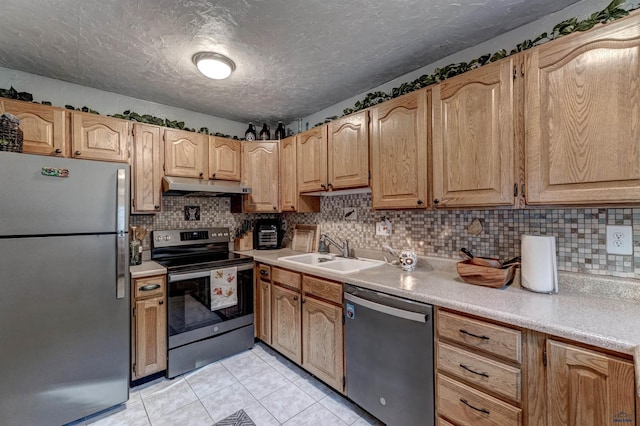 kitchen with sink, a textured ceiling, decorative backsplash, light tile patterned flooring, and appliances with stainless steel finishes