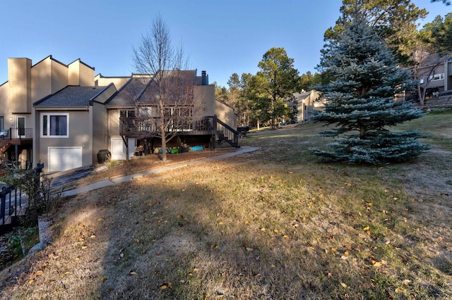 exterior space featuring a yard, a deck, and a garage