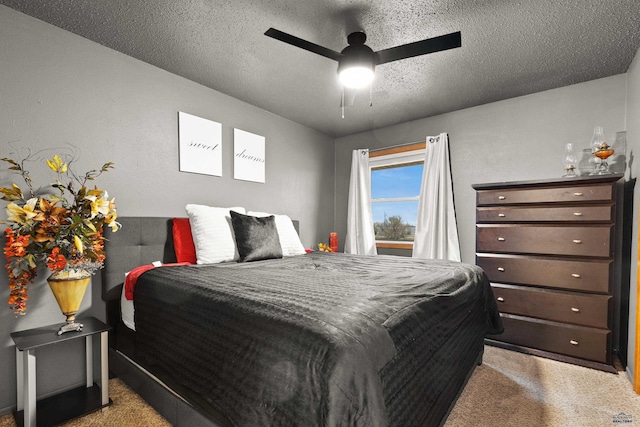 bedroom featuring ceiling fan, light carpet, and a textured ceiling