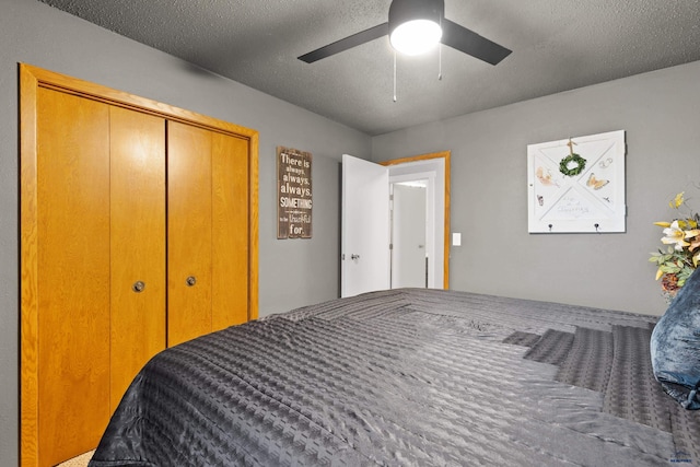 bedroom featuring ceiling fan, a closet, and a textured ceiling