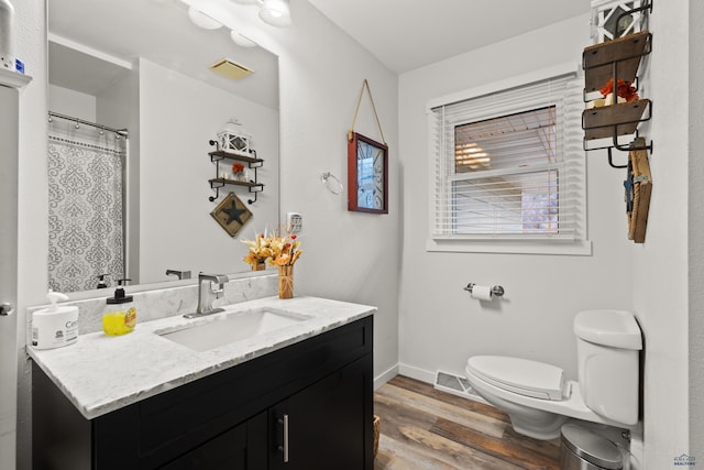 bathroom featuring curtained shower, toilet, vanity, and hardwood / wood-style flooring