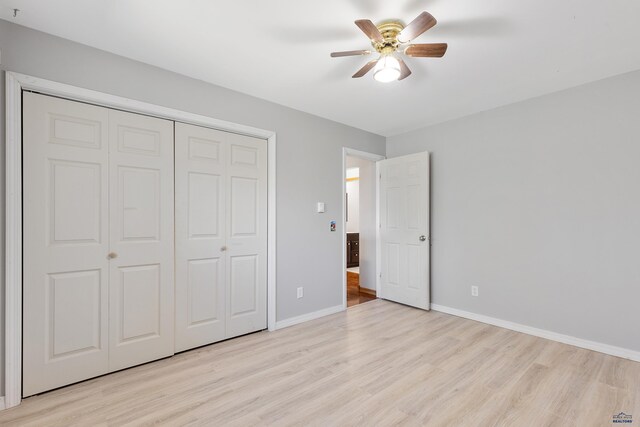 unfurnished bedroom featuring a closet, light hardwood / wood-style floors, and ceiling fan