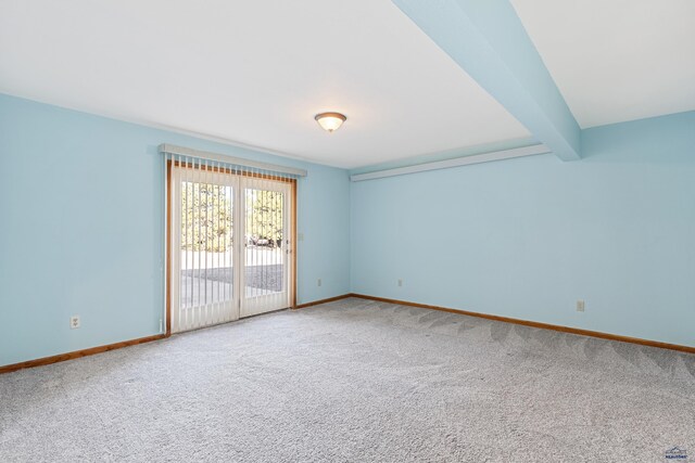 unfurnished room featuring beamed ceiling and carpet floors