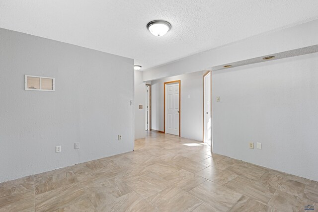 spare room with a textured ceiling