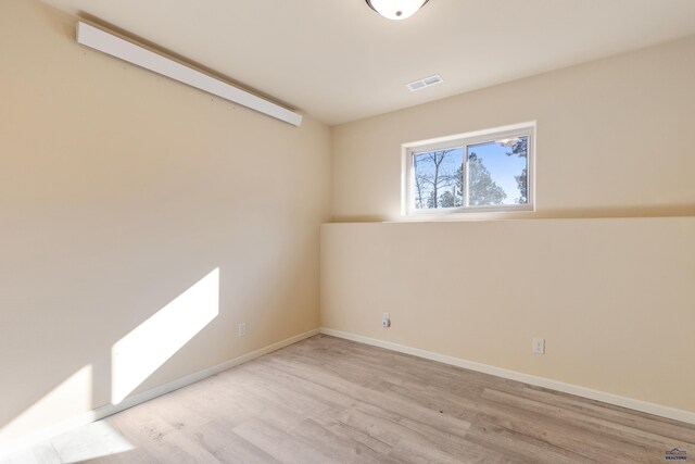 empty room with light hardwood / wood-style flooring