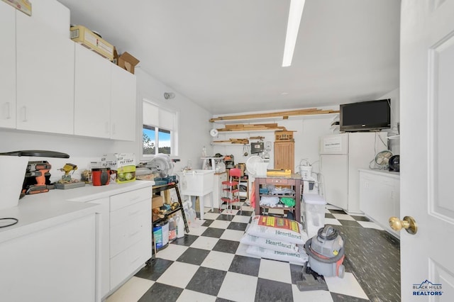 kitchen featuring white cabinets and white refrigerator