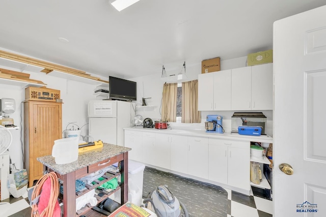 kitchen featuring white cabinets and white refrigerator