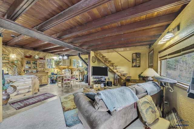 living room featuring beam ceiling, wooden ceiling, and a healthy amount of sunlight