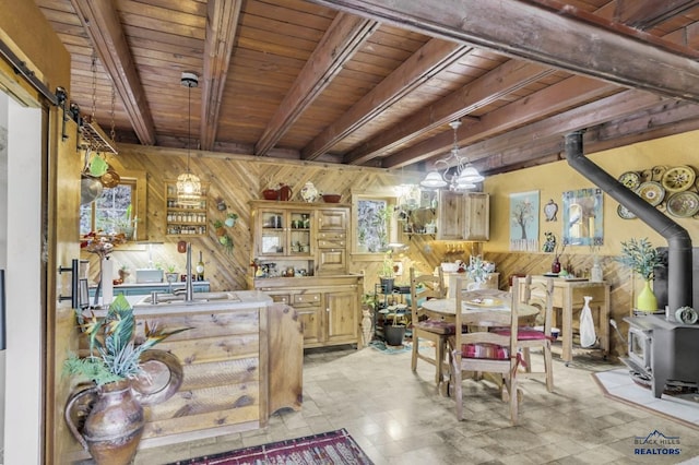 dining area with beamed ceiling, a wood stove, wood walls, and wood ceiling