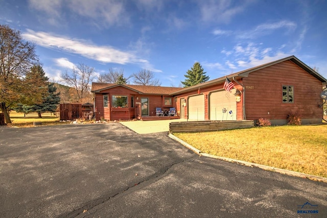 ranch-style house featuring a garage and a front lawn