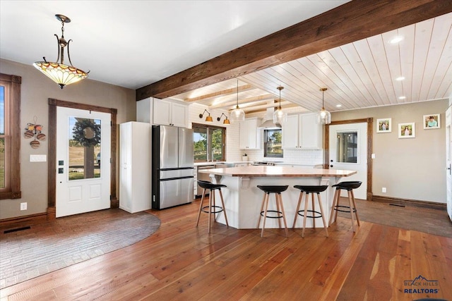 kitchen featuring white cabinetry, pendant lighting, stainless steel appliances, and hardwood / wood-style flooring