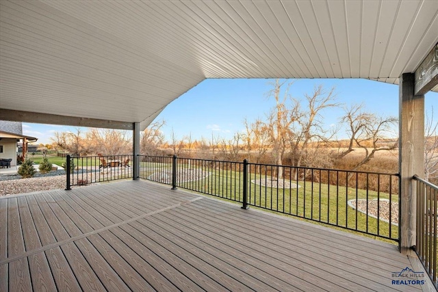 wooden terrace featuring a lawn