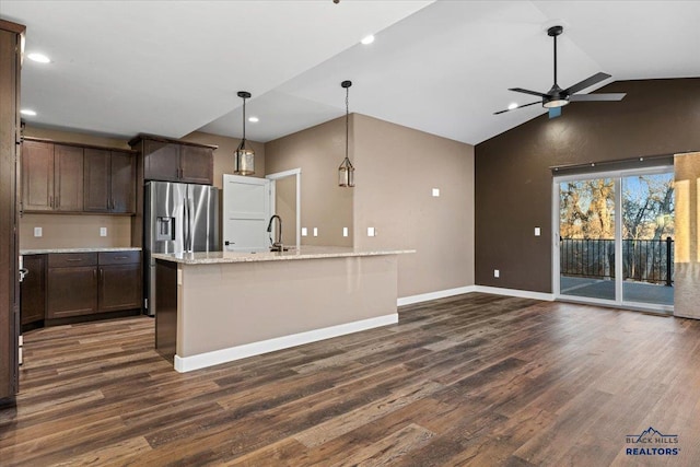 kitchen featuring pendant lighting, dark hardwood / wood-style floors, light stone counters, and dark brown cabinets