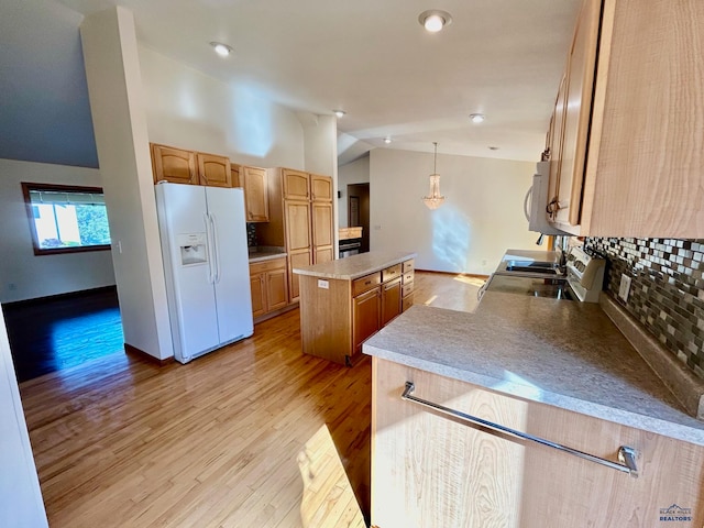 kitchen featuring hanging light fixtures, vaulted ceiling, light wood-type flooring, white fridge with ice dispenser, and a kitchen island