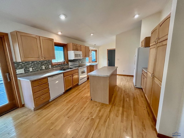 kitchen with light hardwood / wood-style floors, decorative backsplash, a kitchen island, and white appliances