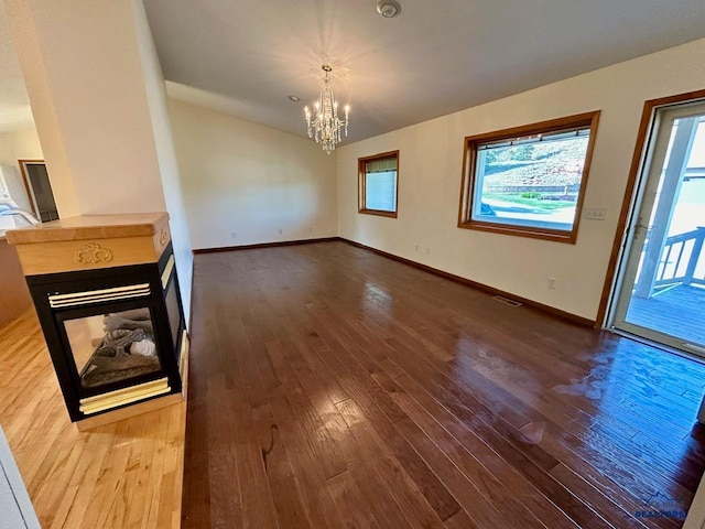 unfurnished living room featuring hardwood / wood-style flooring and a notable chandelier