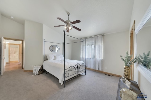 bedroom with ceiling fan, light colored carpet, and high vaulted ceiling