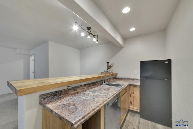 kitchen featuring dishwasher, black fridge, kitchen peninsula, and light wood-type flooring