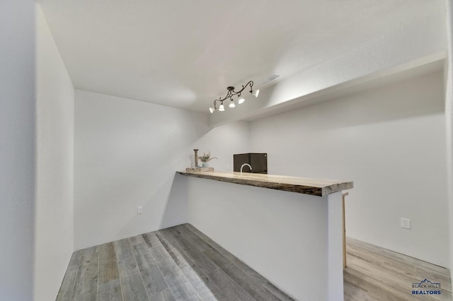 bar with hardwood / wood-style flooring, black fridge, and track lighting