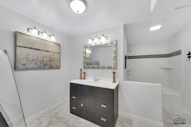 bathroom featuring a tile shower and vanity