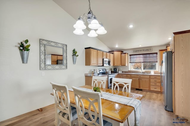 dining space with a notable chandelier, sink, light hardwood / wood-style flooring, and vaulted ceiling