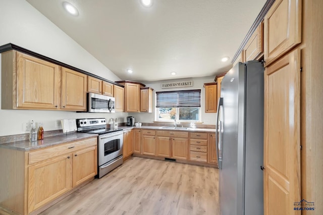 kitchen with sink, light brown cabinets, light hardwood / wood-style flooring, lofted ceiling, and appliances with stainless steel finishes