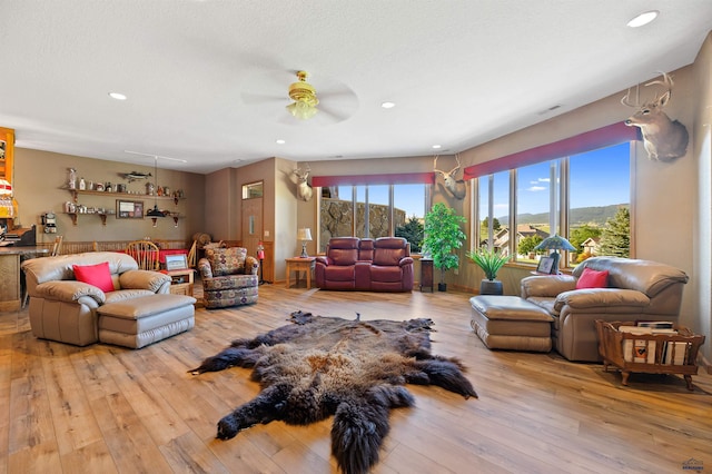 living room featuring light hardwood / wood-style floors and ceiling fan