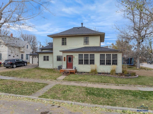 front facade with a front yard, a trampoline, and central air condition unit