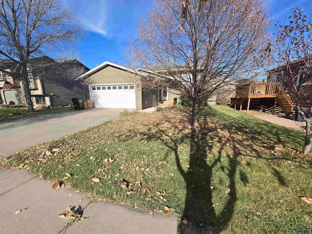 view of front of home with a wooden deck, a front lawn, and a garage