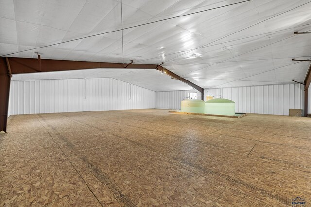 bonus room with wood walls and lofted ceiling