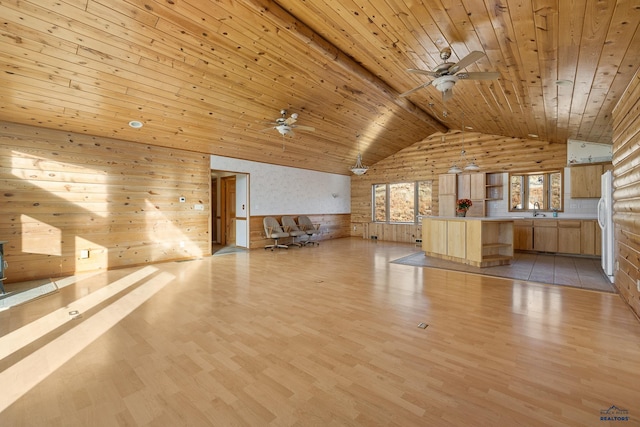 unfurnished living room with light wood-type flooring, sink, wooden ceiling, lofted ceiling, and wood walls