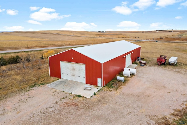 view of outdoor structure with a garage and a rural view