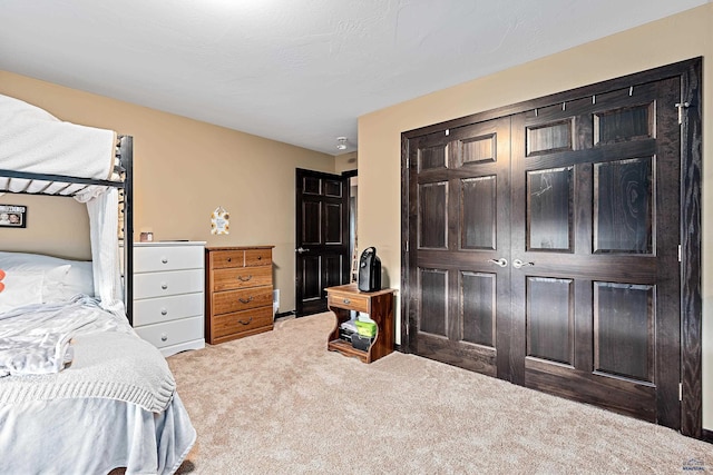 bedroom with light colored carpet and a closet