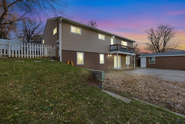 exterior space with a lawn, a balcony, and an outbuilding