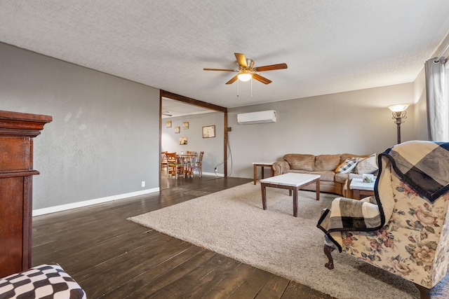 living room with a textured ceiling, dark hardwood / wood-style floors, a wall unit AC, and ceiling fan