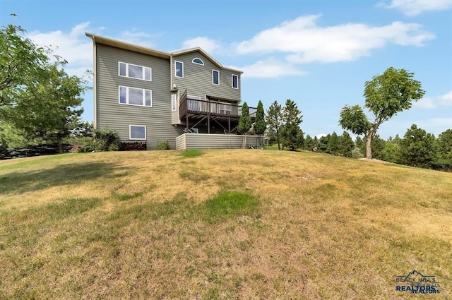 rear view of house with a lawn and a wooden deck