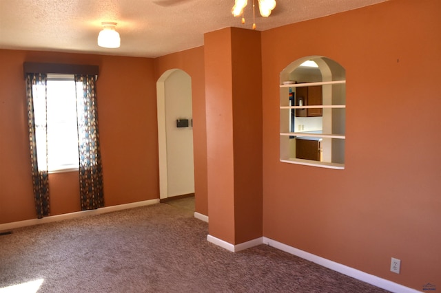 carpeted spare room featuring a textured ceiling