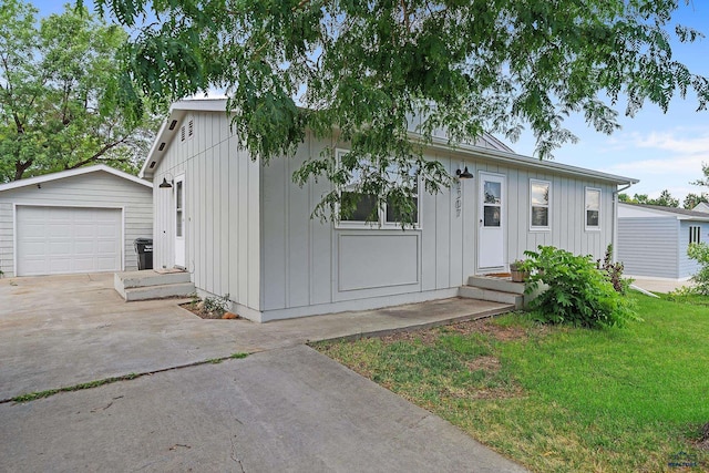 view of front of property with a garage, a front lawn, and an outdoor structure