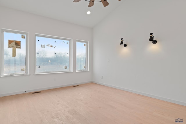 empty room with ceiling fan, light hardwood / wood-style flooring, and lofted ceiling