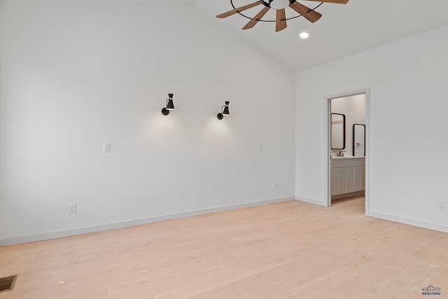 spare room featuring ceiling fan, light hardwood / wood-style floors, and lofted ceiling