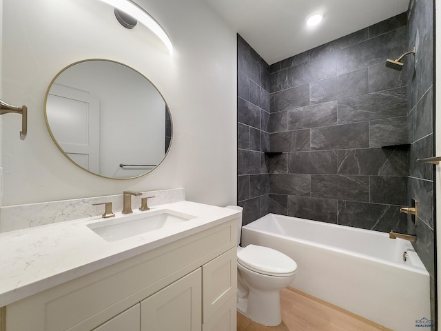 full bathroom with wood-type flooring, vanity, toilet, and tiled shower / bath