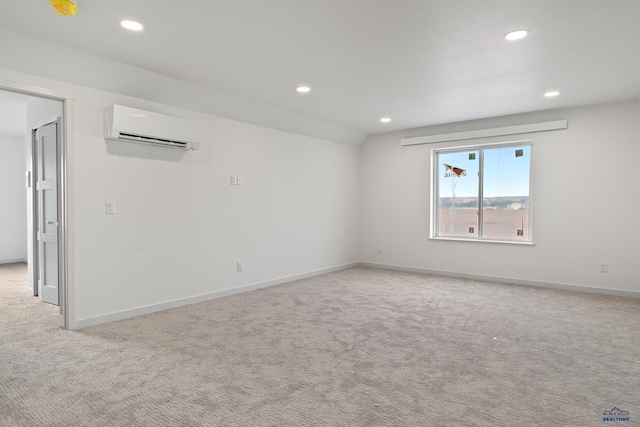 empty room featuring light colored carpet and a wall mounted air conditioner