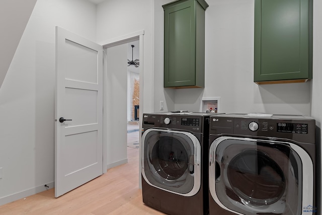 laundry room featuring washer and clothes dryer, light hardwood / wood-style floors, and cabinets