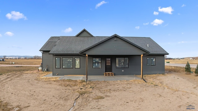 view of front of property with a patio area and a rural view