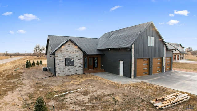 modern farmhouse style home featuring cooling unit and a garage