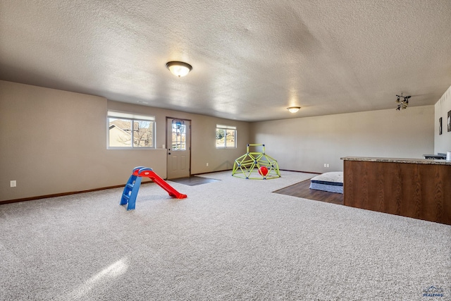 rec room featuring a textured ceiling and carpet floors