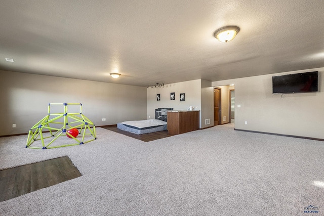 game room featuring a textured ceiling and carpet floors